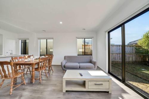 a living room with a couch and a table at Modern Comforts in a Spacious 3BR Family Retreat in Rockbank