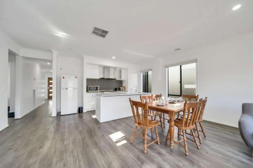 a kitchen and dining room with a table and chairs at Modern Comforts in a Spacious 3BR Family Retreat in Rockbank