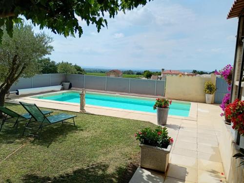 a swimming pool in a yard with a patio at Maison au milieu des vignes in Vacqueyras