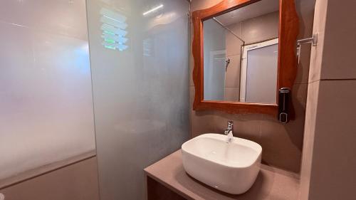a bathroom with a sink and a mirror and a shower at Maitree Beach Resort in Arambol