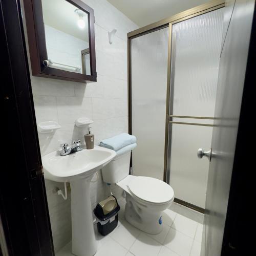 a bathroom with a toilet and a sink and a shower at Mirador Inn in Pasto