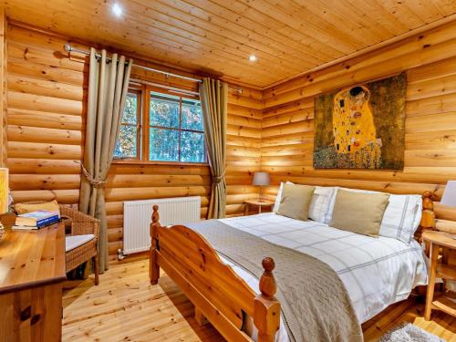 a bedroom with a bed in a log cabin at 3 Bed in Peebles LK15M in Walston