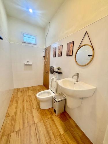 a bathroom with a sink and a toilet and a mirror at บ้านสวนโอเชี่ยน Ocean Garden Home in Chiang Khan
