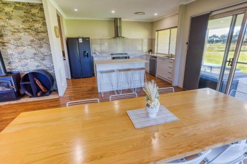 a kitchen with a large wooden table with a potted plant at Chapman Hill Estate in Busselton