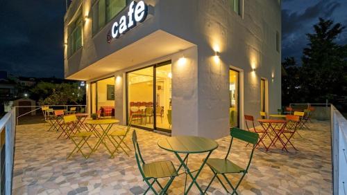 un groupe de chaises et de tables à l'extérieur d'un bâtiment dans l'établissement Gyeongju La Vie en Rose, à Tongnyŏng
