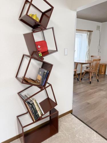 two shelves hanging on a wall with books at Sappro Teine House in Sapporo
