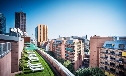 a view of a city with lounge chairs and umbrellas at Grand Hyatt Berlin in Berlin
