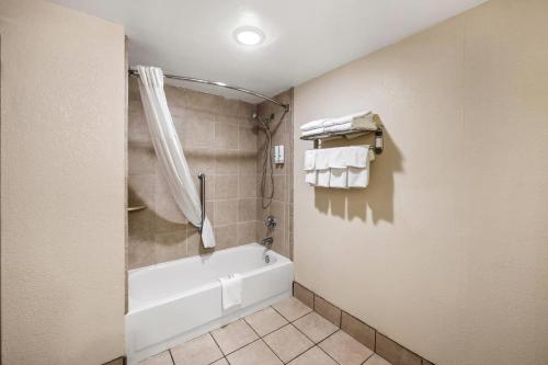 a bathroom with a white tub and a shower at Quality Inn I-81 Exit 23 in Bulls Gap