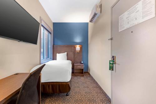 a hotel room with a bed and a flat screen tv at Quality Inn Centre-Ville in Montréal