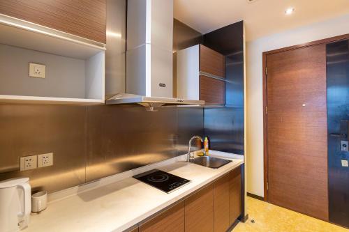 een keuken met een spoelbak en een aanrechtblad bij Aixin Yangtze River International Apartment in Chongqing