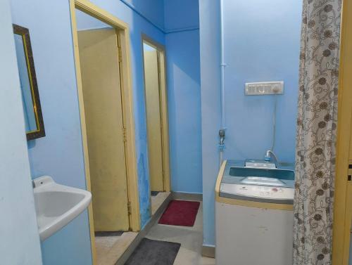 a blue bathroom with a sink and a mirror at KHS Keshav-U in Ambāsamudram