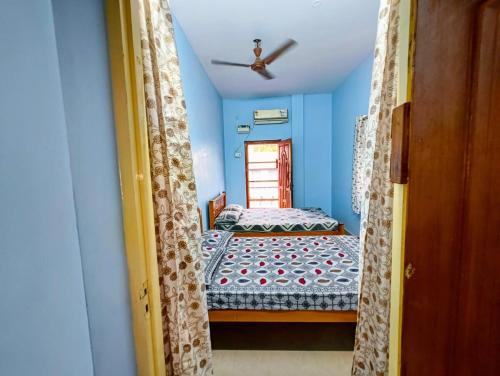 two beds in a room with blue walls at KHS Keshav-U in Ambāsamudram