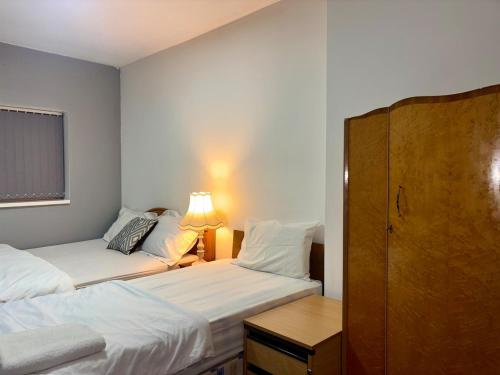 a bedroom with two beds and a desk with a lamp at Family Room on Green road in Dudley
