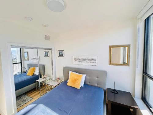 a small bedroom with two beds and a mirror at One Million-Dollar Vista Premium 2-Bed Sky Flat with Lake & City Views in Kelowna