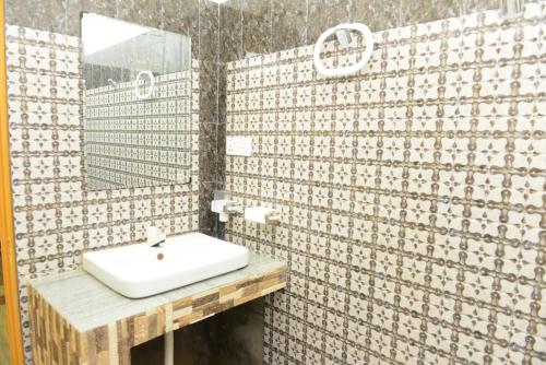 a bathroom with a sink and a mirror at Royal Beach Hotel in Trincomalee