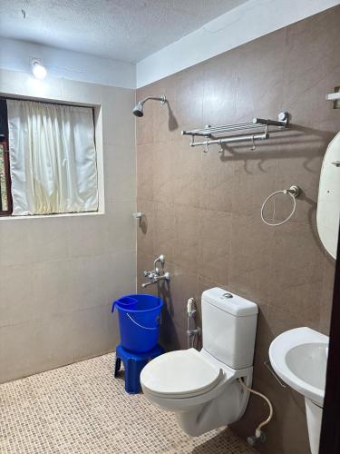 a bathroom with a toilet and a sink at Vilayara Heritage Retreat -Kozhikode in Kunnamangalam