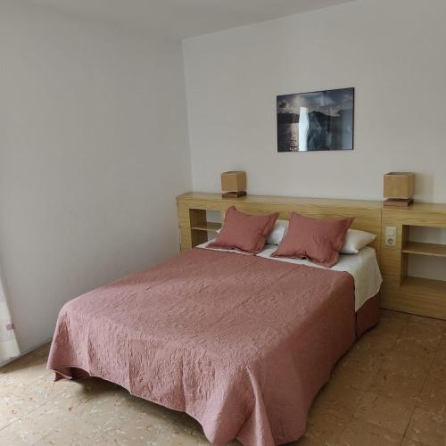 a bedroom with a bed with a pink blanket at Son Quimet in Cadaqués