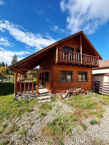 Casa de madera grande con balcón en un campo en Szakács Vendégház, en Borzont