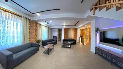 a living room with a couch and a large tv at Pera Apartments in Cristian