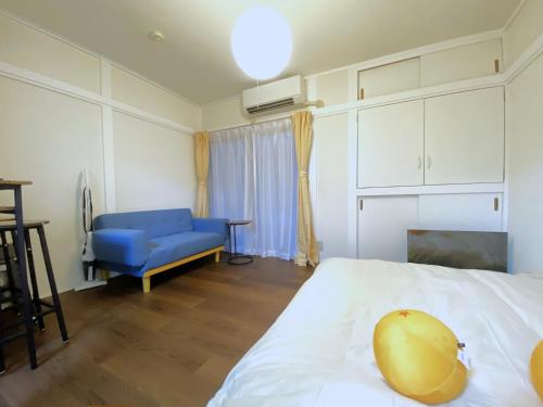 una camera da letto con un letto e una sedia blu di e101 阿佐ヶ谷ローズハウス a Tokyo