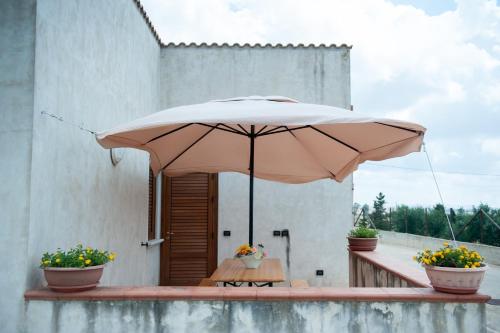 a large tan umbrella sitting on a patio at Casavacanza Dattilo in Dattilo
