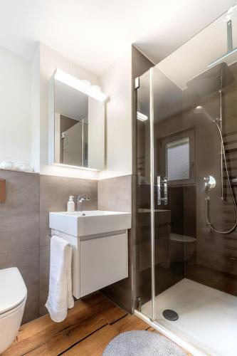 a bathroom with a sink and a shower and a toilet at Alpine Lodge 63 in Andermatt
