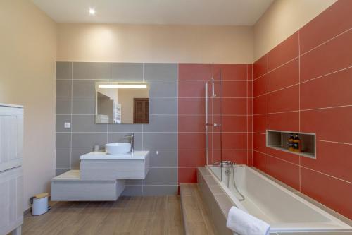 a bathroom with a tub and a sink and a bath tubermott at La Bastide - 8 personnes - Maison avec jardin in Lescar