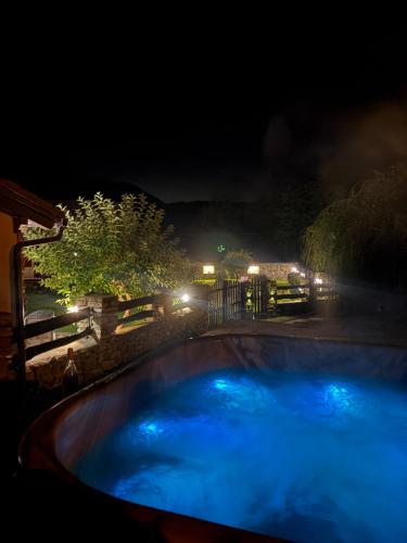 a swimming pool at night with blue lights at Casa de Piatra in Strungari