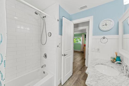 Un baño blanco con bañera y lavabo. en 4822 Fairview Dr, en Cabo Cañaveral
