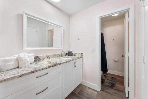 Un baño blanco con lavabo y espejo. en 311 Jack Dr, en Cocoa Beach