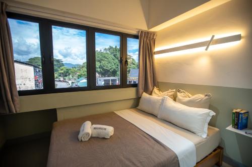 a hotel room with a bed with a window at The Brownstone Hostel & Space in Ipoh