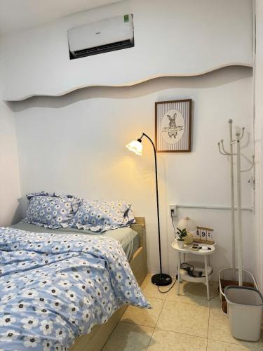 a bedroom with a bed and a lamp at Nap House 2- house in center Phan Thiet in Ấp Bình Hưng