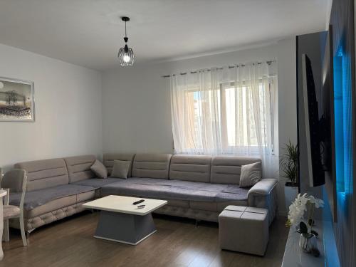 a living room with a couch and a table at Mme apartment in Kamëz