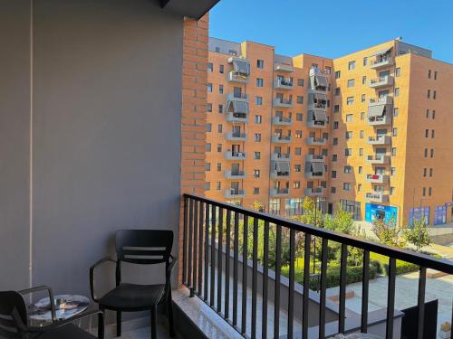a balcony with a chair and a table and some buildings at Mme apartment in Kamëz