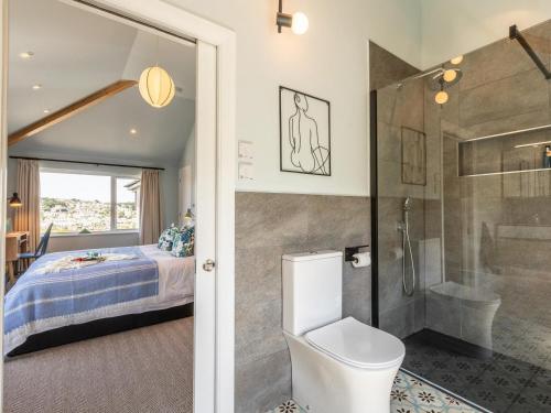 a bathroom with a toilet and a shower and a bed at 5 Bed in Polruan 93849 in Polruan