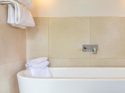 セント・メスリオンにある2 Bed in St. Mellion 87706のバスルーム(バスタブ、壁にタオル付)