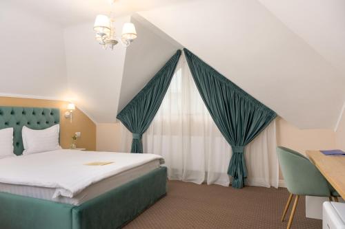 a bedroom with a bed and a window with curtains at Pensiunea Casa Sturza in Bacău