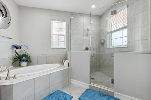 Un baño blanco con bañera y ducha. en 148 Mediterranean Way, en Indian Harbour Beach