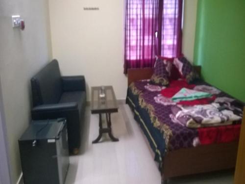 a small bedroom with a bed and a chair at Hotel Cosy Inn in Digha