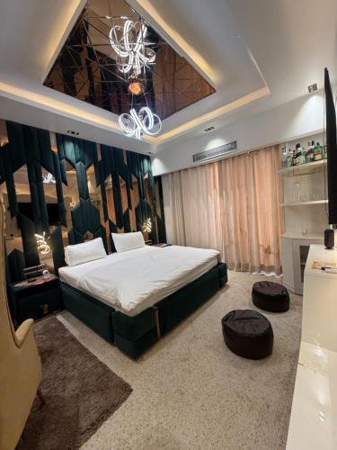 Un dormitorio con una cama grande y una lámpara de araña. en Omaxe Hazratganj Studios, en Lucknow