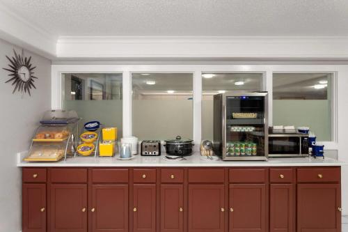 a kitchen with brown cabinets and a counter top at Days Inn & Suites by Wyndham Arlington Heights in Arlington Heights