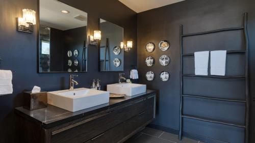 a bathroom with two sinks and a mirror at Iconic 6BR Desert Retreat w Pool Pickleball Fire Pit Joshua Tree Masion by AvantStay in Joshua Tree