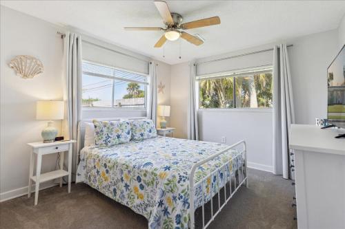 Un dormitorio con una cama y un ventilador de techo. en 4880 N Banana River Sandys Place, en Cocoa Beach