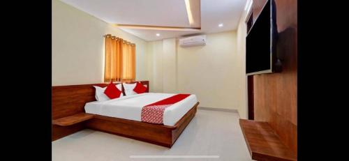 BidadiにあるHotel O Bidadi Railway Junction Bangalore Formerly Ejallaのベッドと薄型テレビのある寝室
