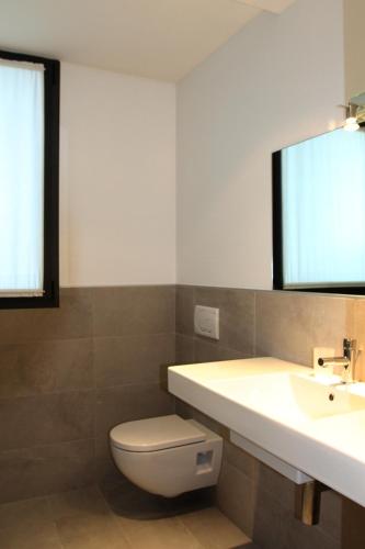 a bathroom with a toilet and a sink and a mirror at Residence Ormeggio in Grado