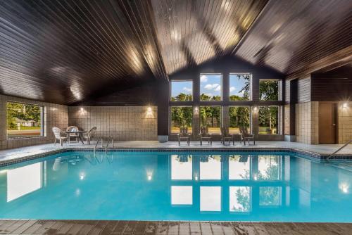 a swimming pool in a house with a large window at Baymont by Wyndham Bloomington MSP Airport in Richfield