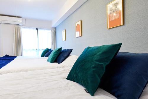 a room with three beds with green pillows at 梅田から1駅 - Umeda 1stop, Shin-Osaka 10m, 2m to Sta, 2F - XS41 in Osaka
