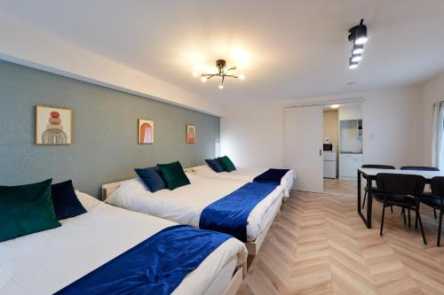 two beds in a room with a table and chairs at 梅田から1駅 - Umeda 1stop, Shin-Osaka 10m, 2m to Sta, 2F - XS41 in Osaka