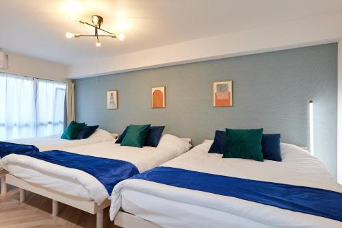 two beds in a room with blue and white at 梅田から1駅 - Umeda 1stop, Shin-Osaka 10m, 2m to Sta, 2F - XS41 in Osaka