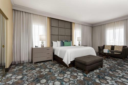 a large bedroom with a large bed and a chair at Hawthorn Extended Stay by Wyndham West Palm Beach in West Palm Beach